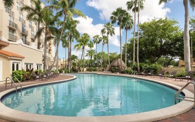 Beautiful outdoor pool with lounge chairs at Embassy Suites By Hilton Miami - International Airport.