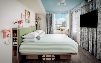 Day use room with king bed, TV screen, large windows and private bathroom at The Goodtime Hotel.