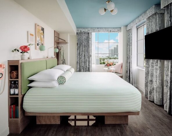 Day use room with king bed, TV screen, large windows and private bathroom at The Goodtime Hotel.