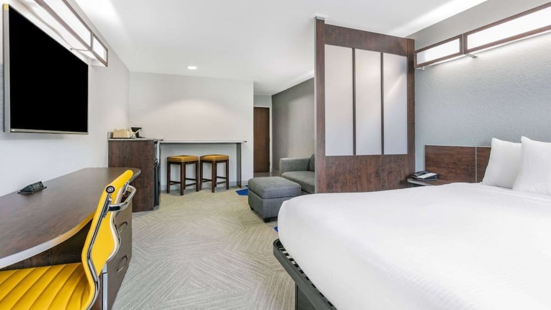 Day use room with TV and work desk at Microtel Inn And Suites By Wyndham Austin Airport.