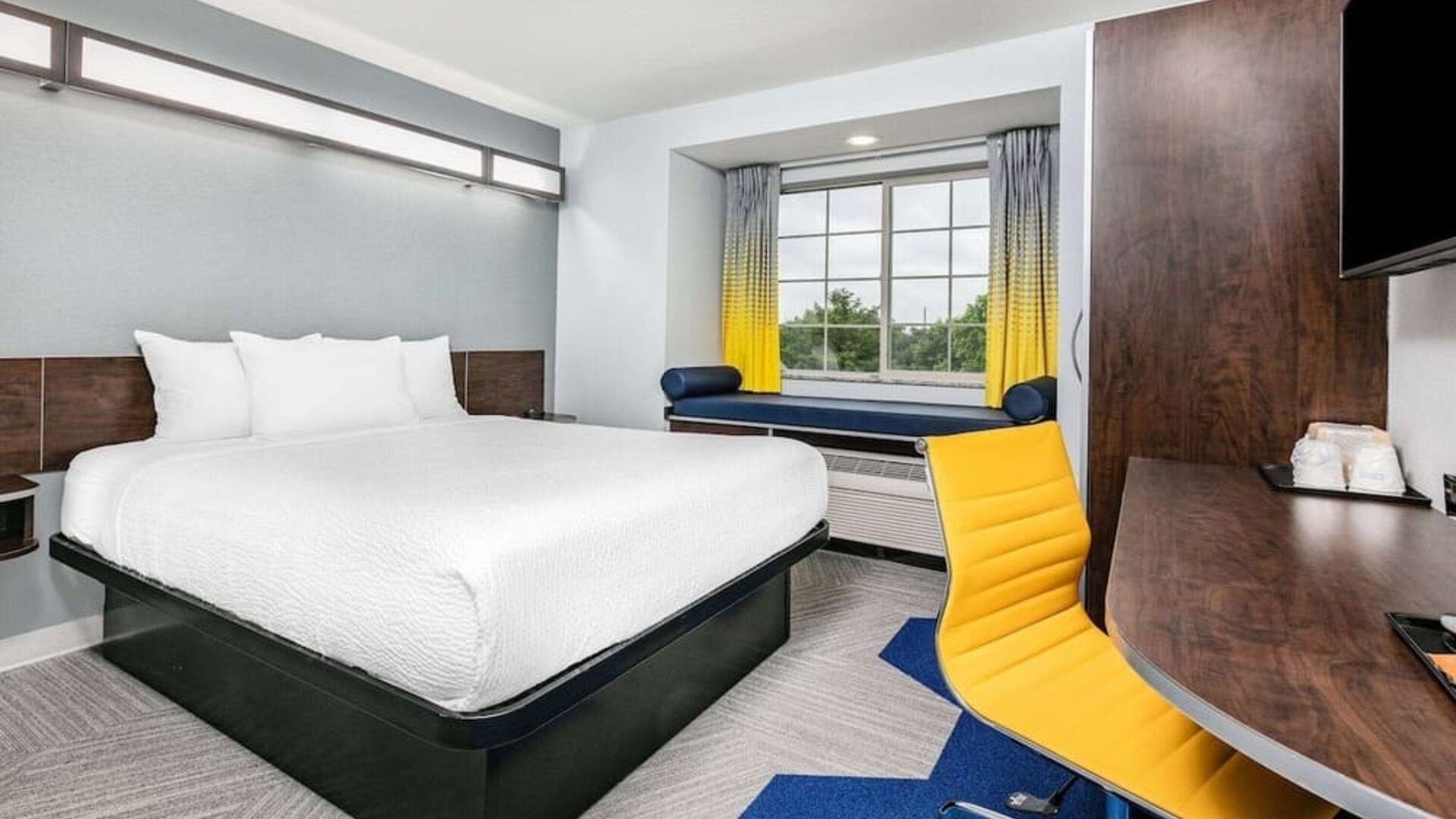 Day use room with TV and work desk at Microtel Inn And Suites By Wyndham Austin Airport.