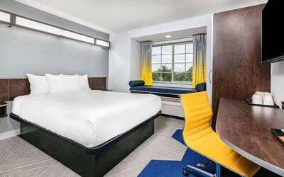 Day use room with TV and work desk at Microtel Inn And Suites By Wyndham Austin Airport.
