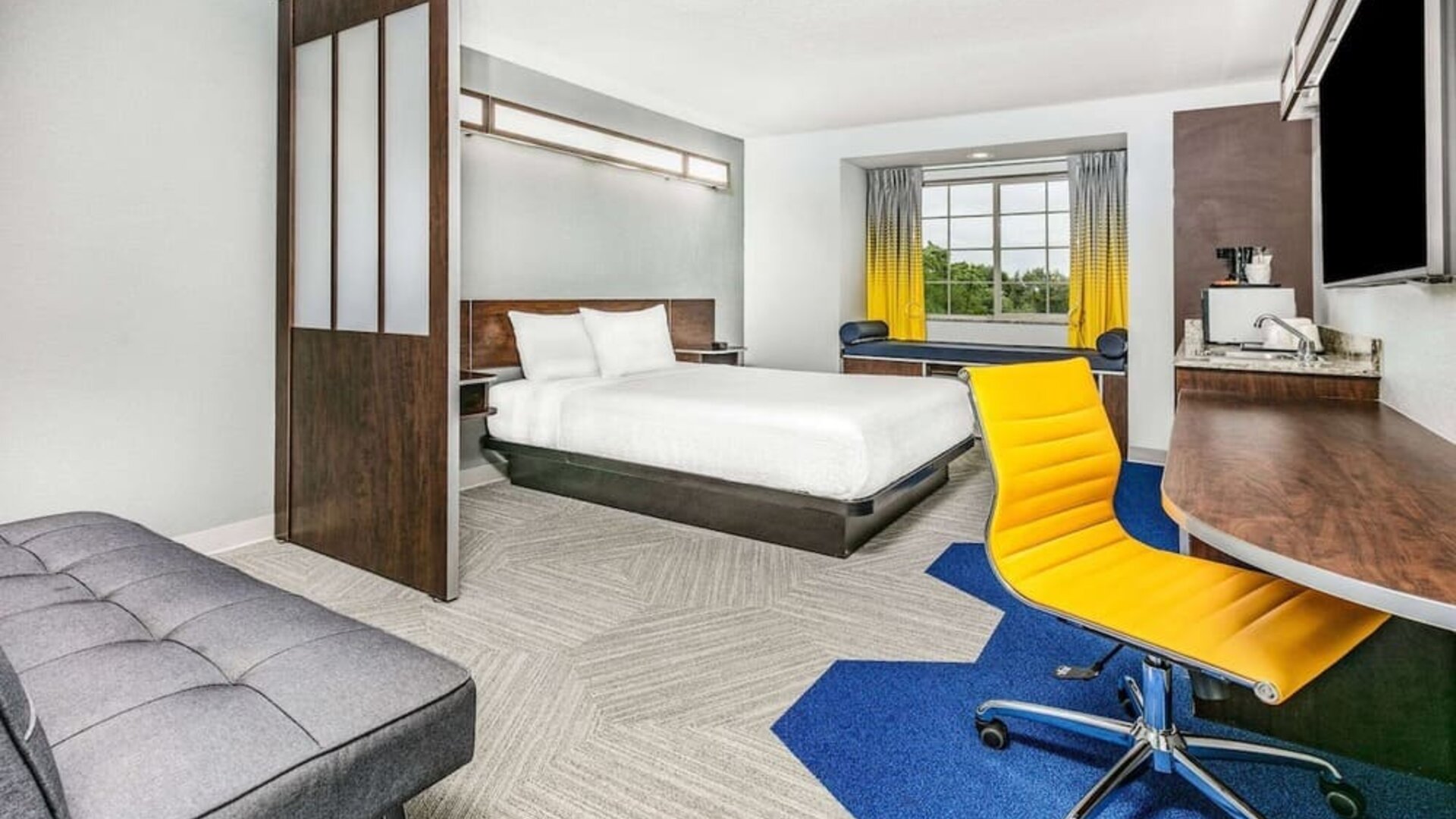 Day use room with TV and work desk at Microtel Inn And Suites By Wyndham Austin Airport.