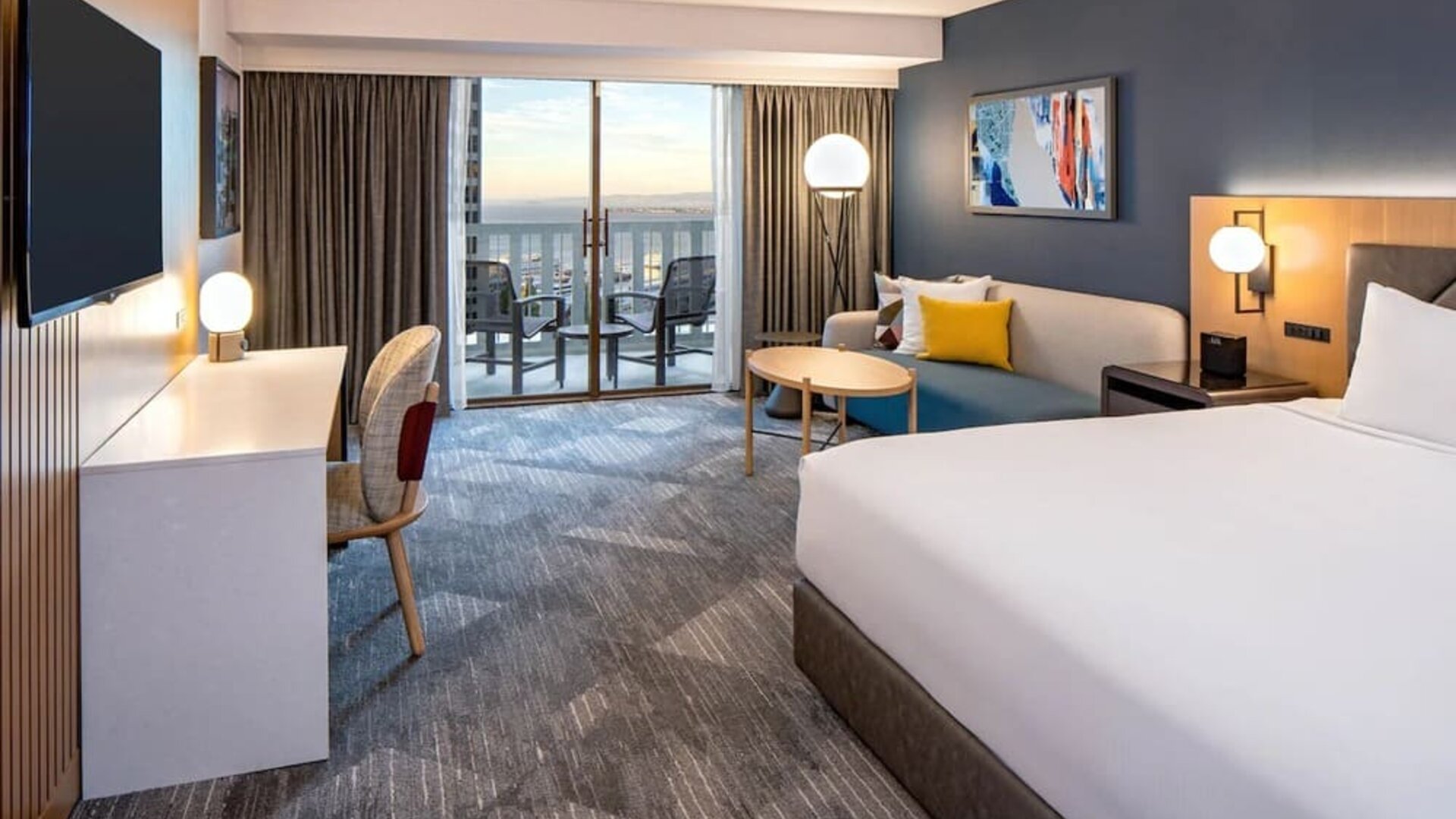 King bedroom with desk and balcony at Hyatt Regency San Francisco.
