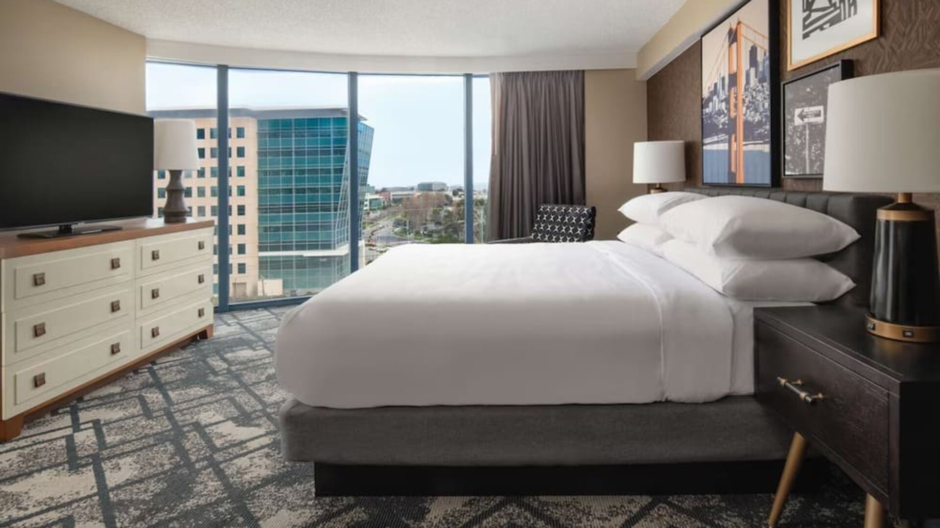 King size bed, TV and large window at Embassy Suites by Hilton San Francisco Airport.