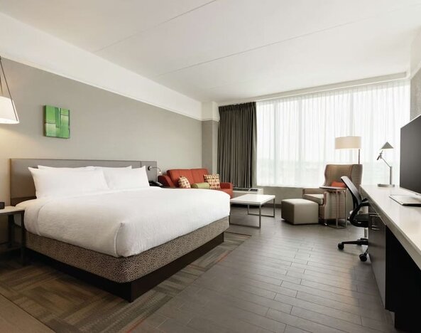 Delux king room with sofa, work desk and TV at Hilton Garden Inn Calgary Downtown.