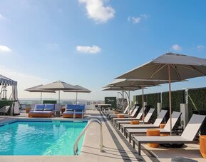 Relaxing outdoor pool with lounge chairs at Montrose At Beverly Hills.