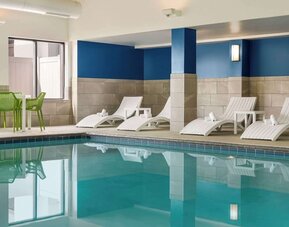 Indoor pool with lounge chairs at Hampton Inn Chicago-O'Hare International Airport.