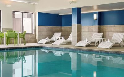 Indoor pool with lounge chairs at Hampton Inn Chicago-O'Hare International Airport.