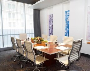 Professional meeting room with large table and ergonomic chairs at Hotel 48LEX New York.