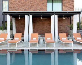 Outdoor pool and sun loungers at Canopy By Hilton Austin Downtown.