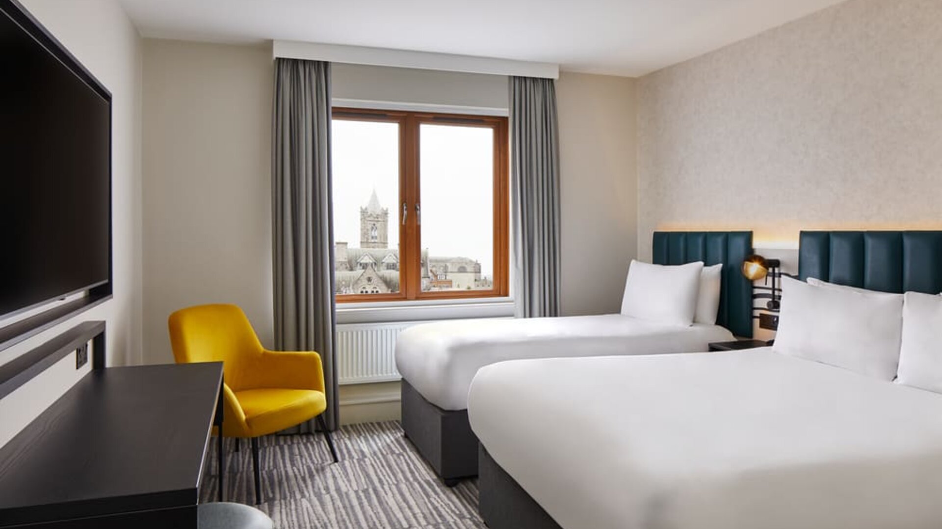 Two beds with TV at Leonardo Hotel Dublin Christchurch.