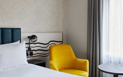 King room with chair at Leonardo Hotel Dublin Christchurch.