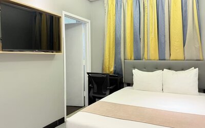 Madison LES Hotel room with double bed, and desk for working.