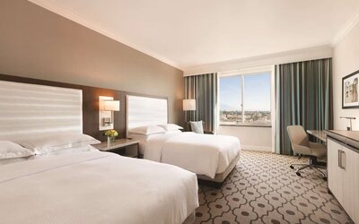 Comfortable day room with natural light, desk and chair at Hilton Los Angeles/San Gabriel for a relaxing daycation.