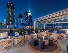 Rooftop bar with seating and beautiful city views at Hilton Fashion District.