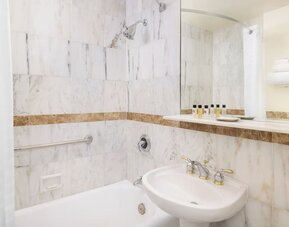 Modern bathroom with plush towels at New Yorker by Lotte Hotels