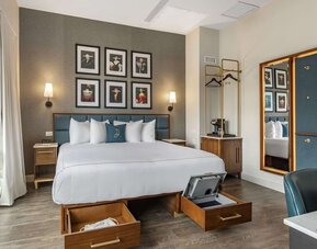 Guest room at The Draper Tapestry Collection By Hilton with workspace desk and chair, plus city views.
