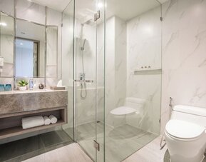 Modern bathroom with plush towels at Divalux Resort & Spa Bangkok Suvarnabhumi Airport.