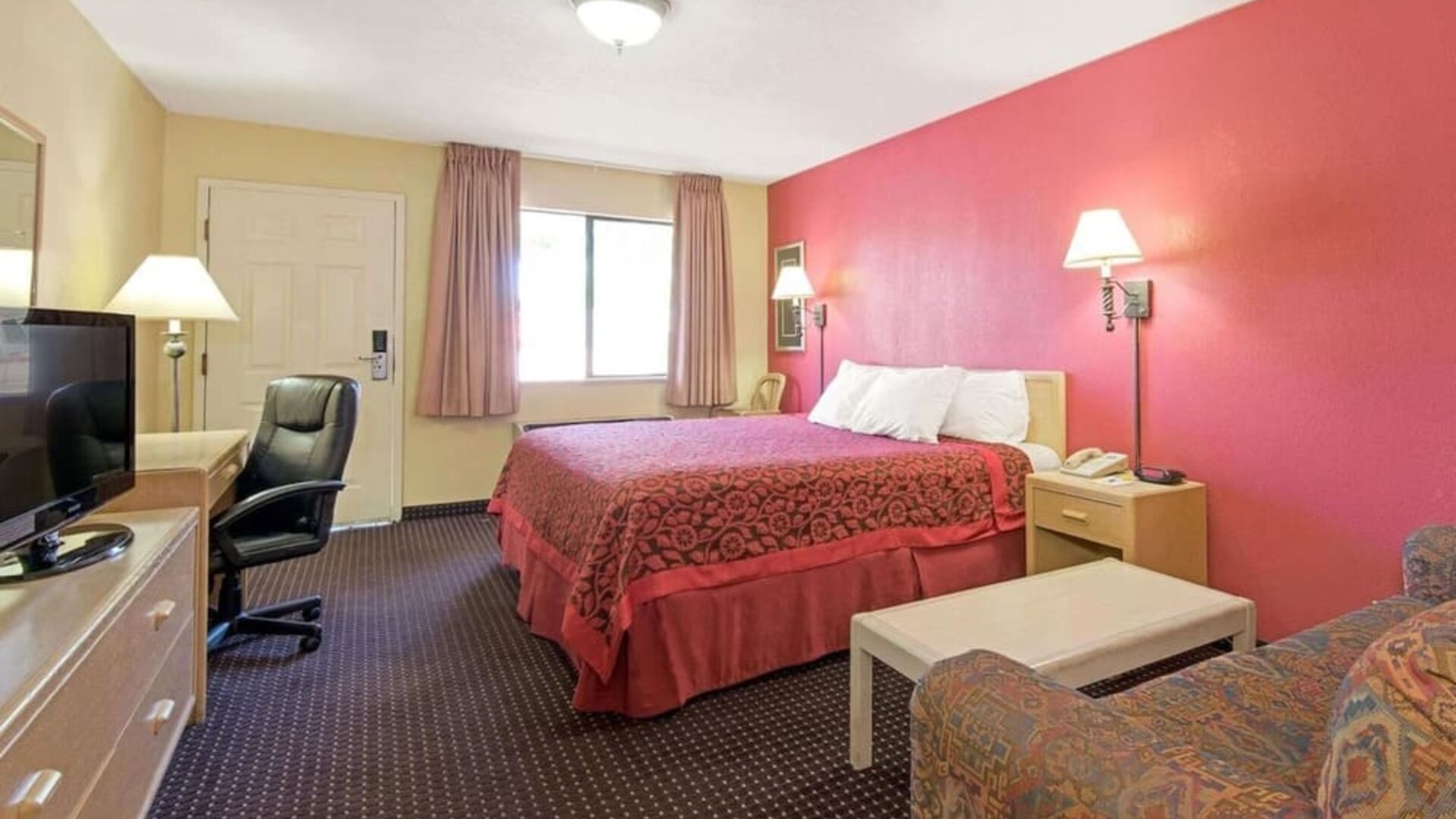 Day room with work desk and couch at Days Inn By Wyndham East Albuquerque.