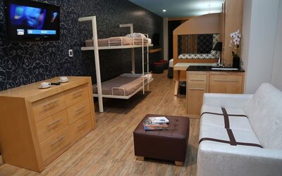 Room at the TRYP By Wyndham Times Square South containing desk, double bed, bunk beds and a couch.