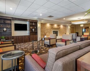 Lobby with comfortable seating and a television at Comfort Inn Glenmont - Albany South.
