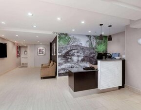 Welcoming reception area with comfortable seating at La Quinta Inn & Suites By Wyndham New York City Central Park.