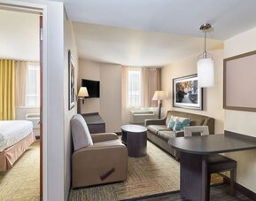 Day room at Candlewood Suites Times Square, with workspace, couch and large window.