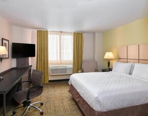 Day room at the Candlewood Suites Times Square, with workspace nearby and large window.