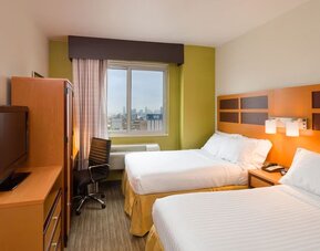 Day room at the Holiday Inn Express Times Square’s with workspace and a televison.