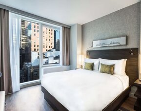 Day use room with large windows providing a beautiful view of the city at The Bernic Hotel New York City, Tapestry Collection By Hilton.