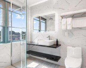 Modern bathroom with plush towels at Liberty View Brooklyn Hotel.