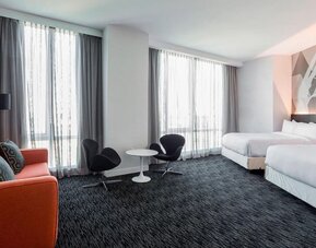 Day use room with a couch, workspace and natural light at Courtyard By Marriott Long Island City/New York Manhattan View.