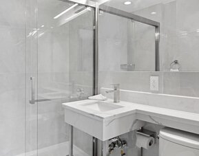 Modern bathroom with towels at Hotel 365 Bronx.