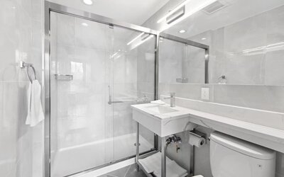 Modern bathroom with towels at Hotel 365 Bronx.