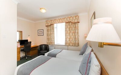 Day room with workspace and a couch at Stade Court Hotel.