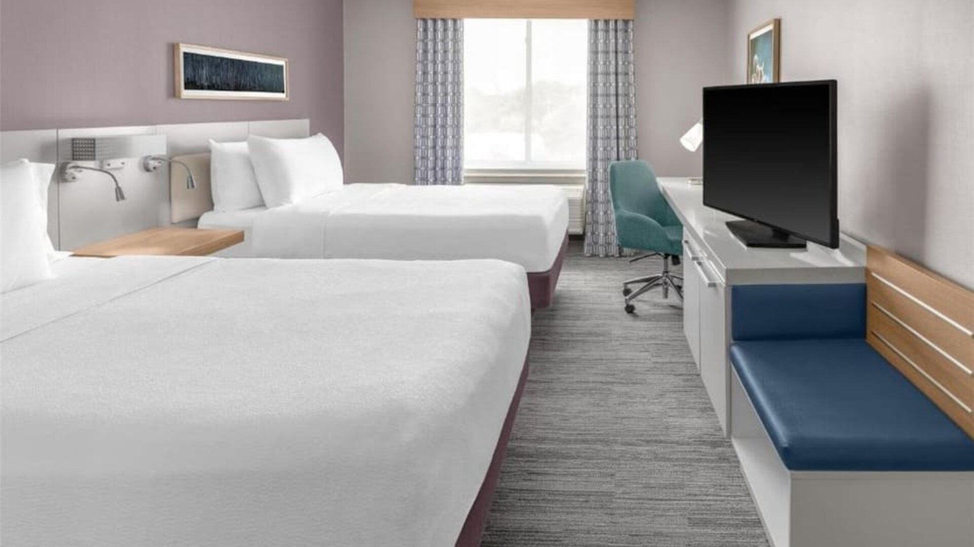 Guest room at Hilton Garden Inn Queens/JFK Airport with two double beds, desk, seating, and window.