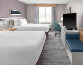 Guest room at Hilton Garden Inn Queens/JFK Airport with two double beds, desk, seating, and window.