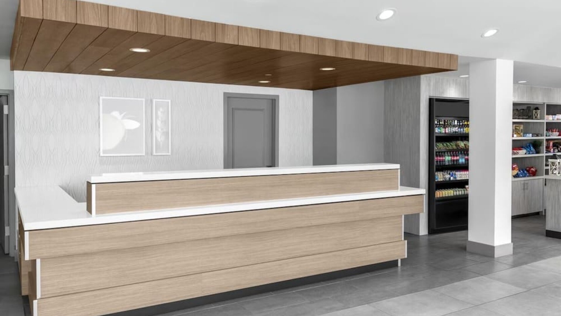 Reception area at Hilton Garden Inn Queens/JFK Airport with wood desk, and a white counter.