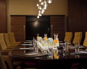 Boardroom with long table, chairs and decorative lighting at Renaissance Newark Airport Hotel.