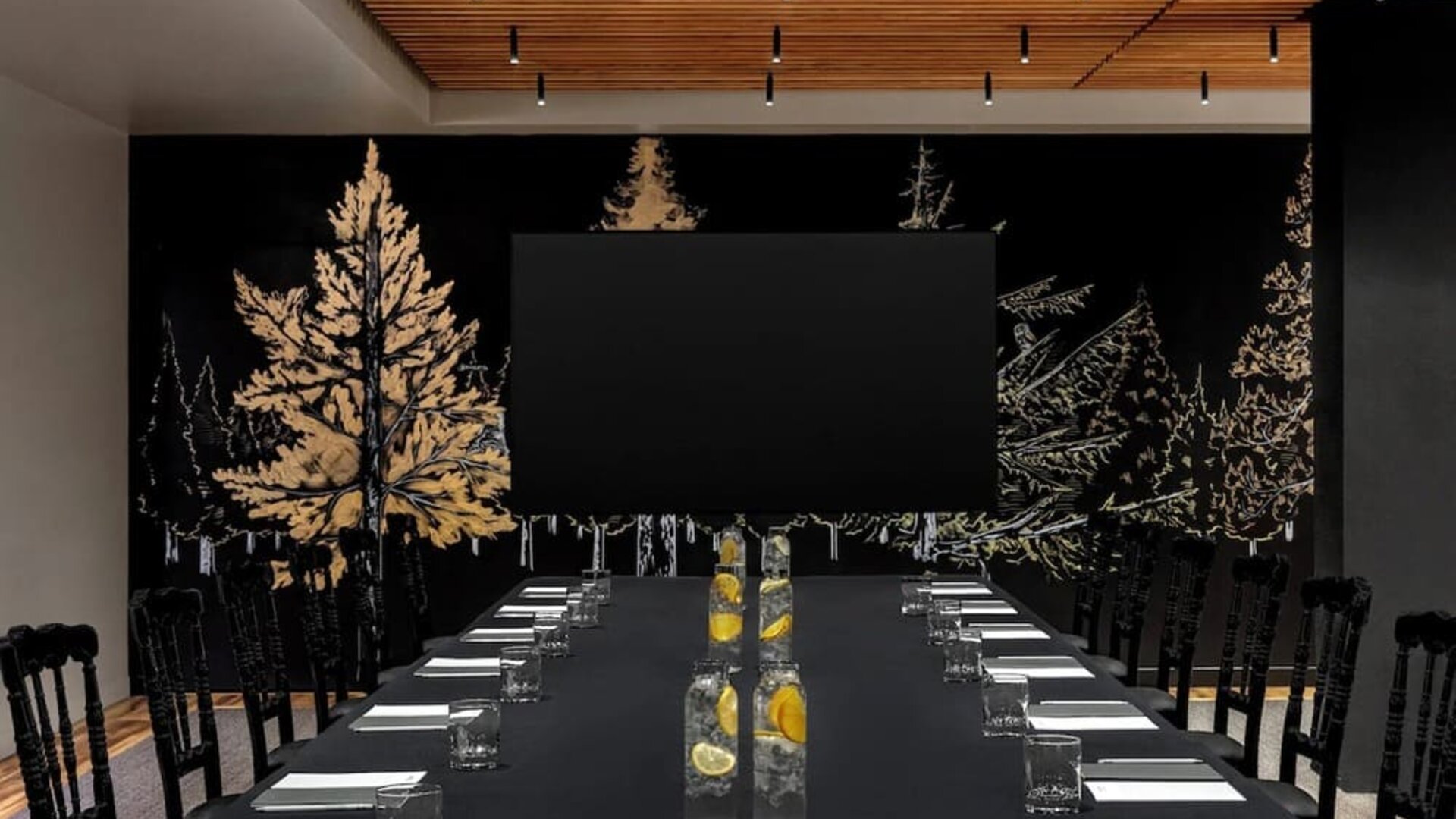 Conference setup with long table, water bottles, notepads, and large screen at Kimpton Palladian Hotel.