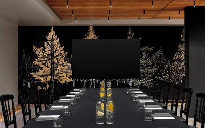 Conference setup with long table, water bottles, notepads, and large screen at Kimpton Palladian Hotel.