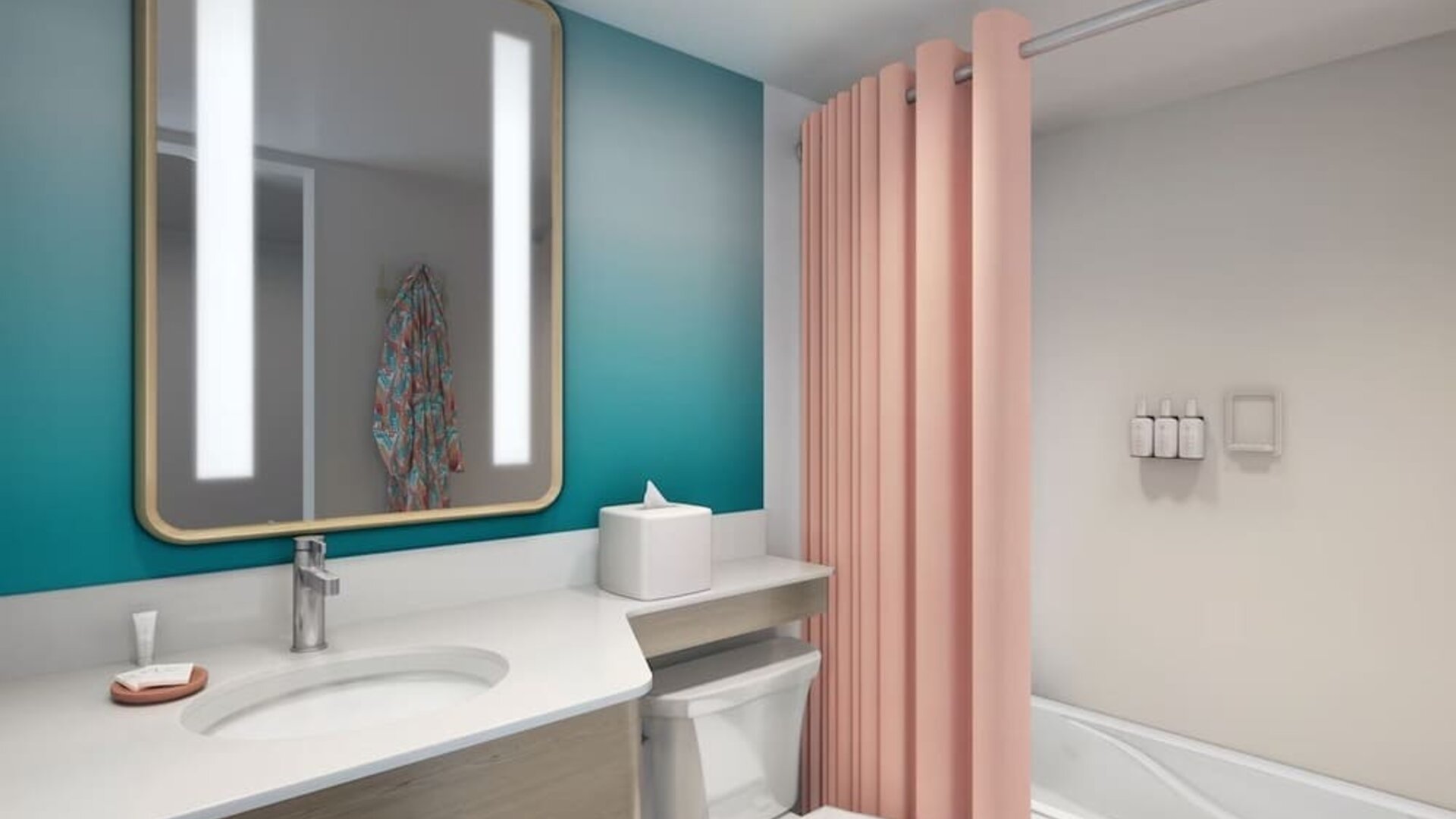 Bathroom with vanity, illuminated mirror, bathtub with pink curtain, and teal accent wall at The Twin Fin Hotel.