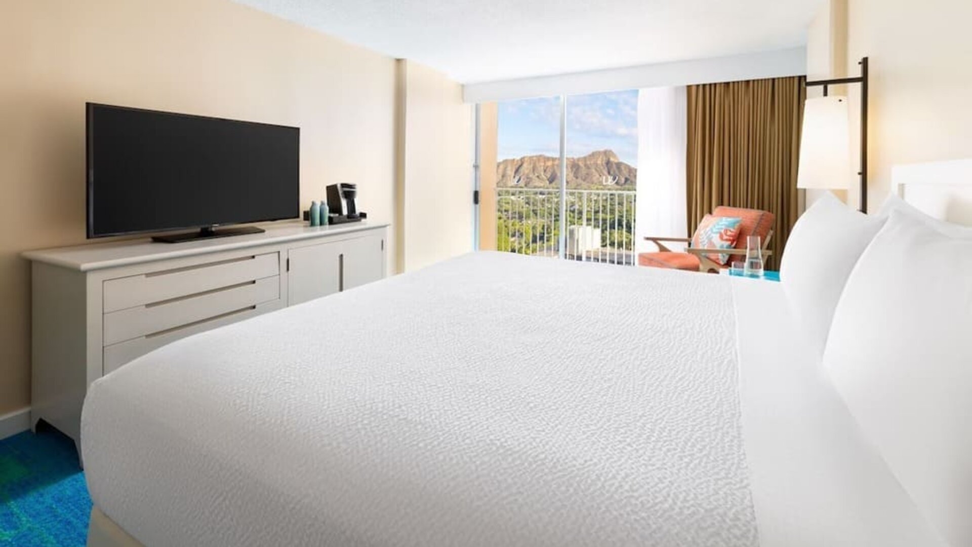 Close view of king bed facing balcony with mountain view at The Twin Fin Hotel.