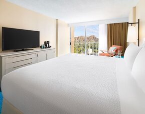 Close view of king bed facing balcony with mountain view at The Twin Fin Hotel.