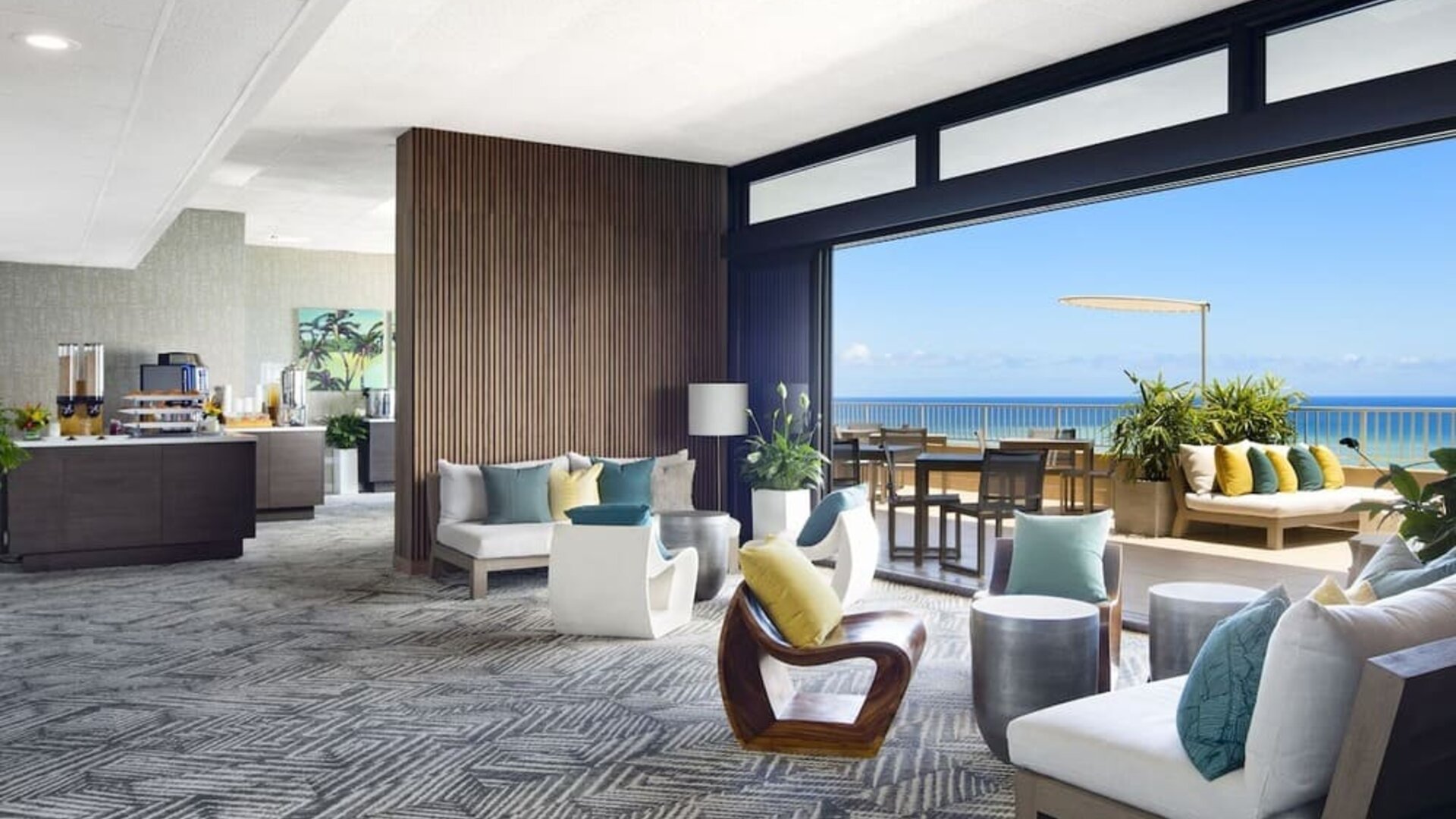 Open lounge with ocean-view terrace seating and modern indoor furnishings at The Twin Fin Hotel.