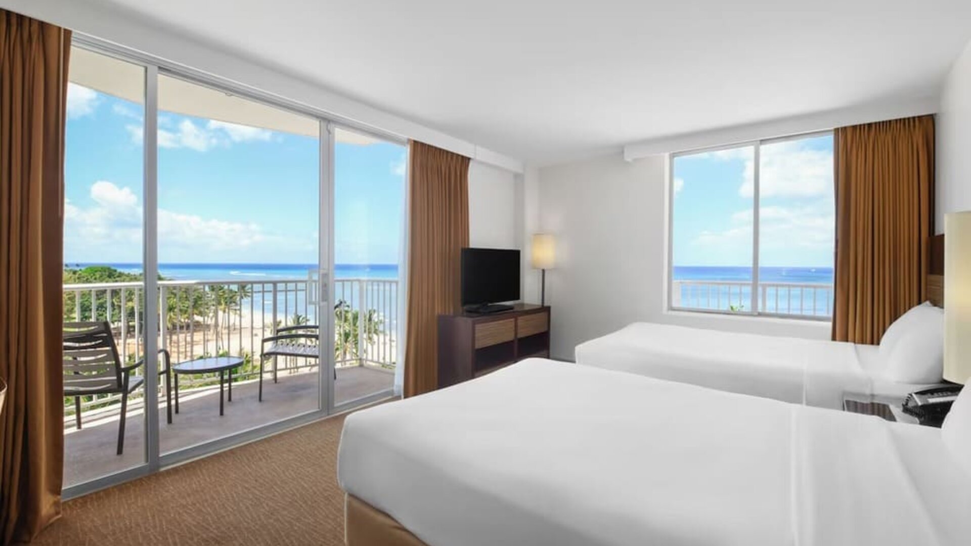 Room with two double beds, large windows, balcony, and ocean views at Park Shore Waikiki.