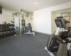 Fitness center with free weights, cable machine, and exercise bike at Park Shore Waikiki.
