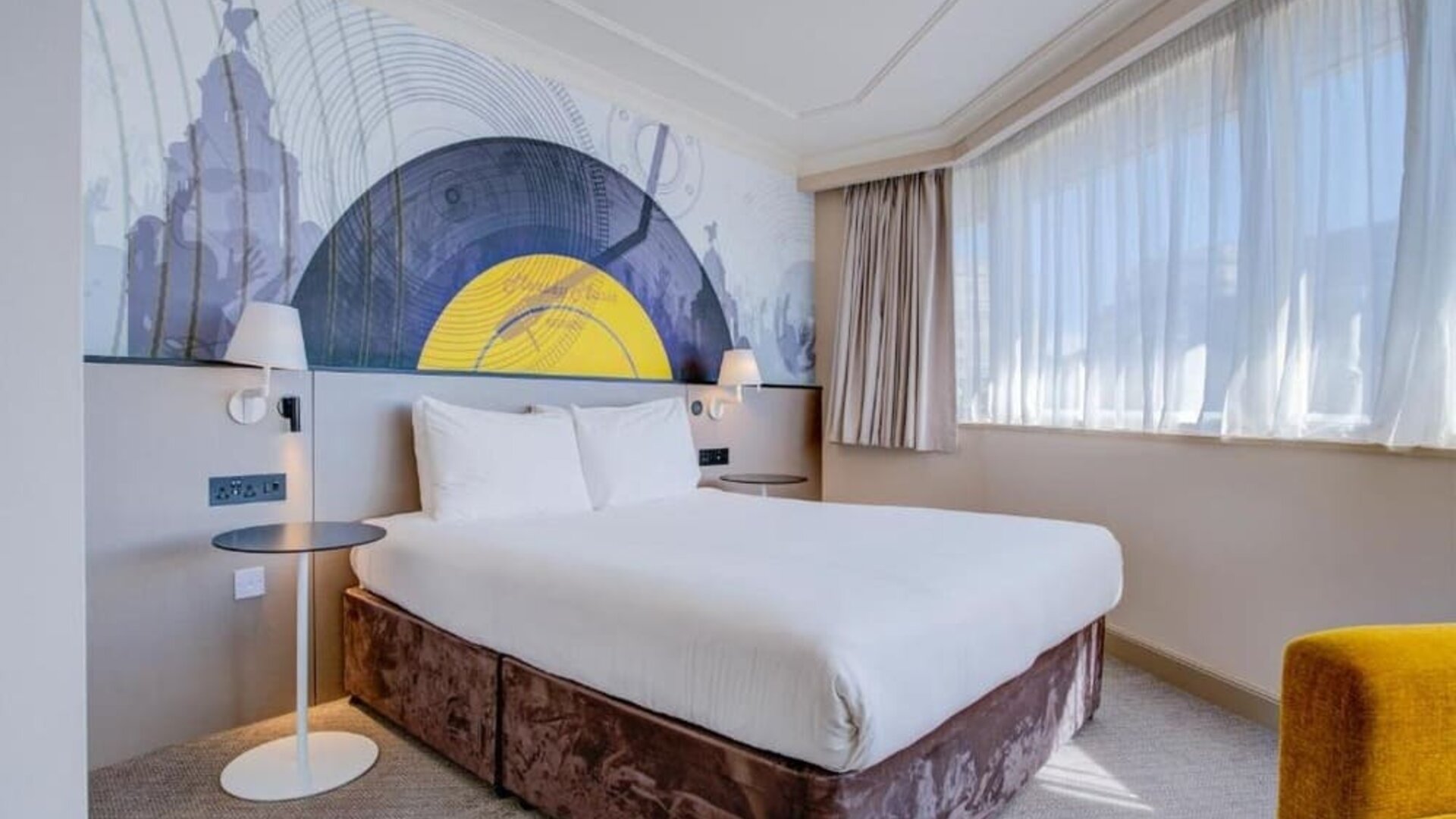 Bright double room with large bed, abstract mural headboard, and natural light from wide windows at Atlantic Tower Hotel Liverpool By Sunday.