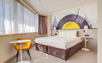 Spacious double room with large bed, side tables, and seating area by the window at Atlantic Tower Hotel Liverpool By Sunday.